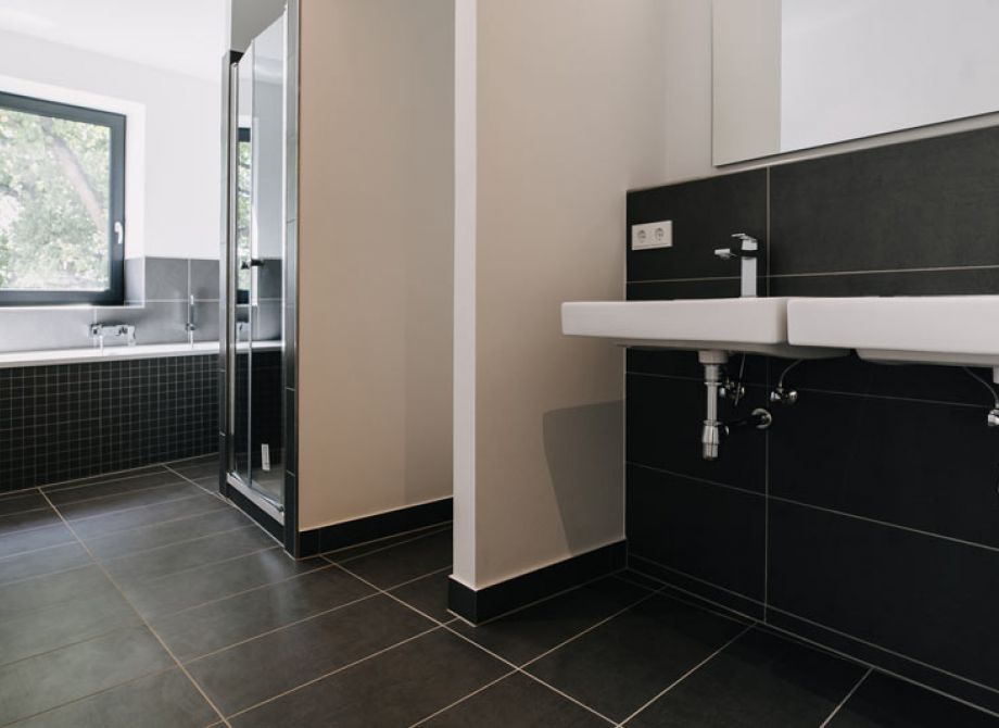 Modernes Badezimmer mit Badewanne, Dusche und Doppelwaschbecken in einer Wohnimmobilie
