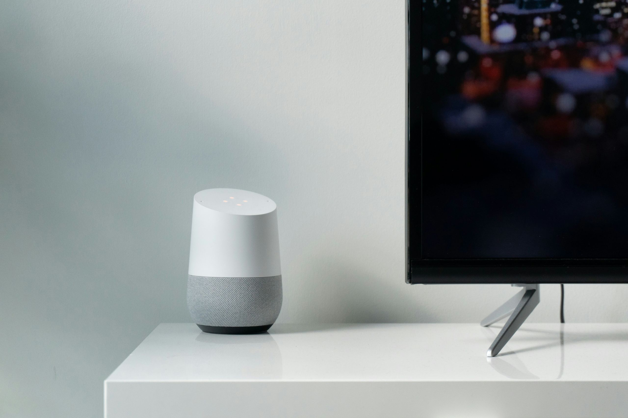 Smart-Home-Lautsprecher neben Fernseher als Symbol für modernes Wohnen und digitale Ausstattung
