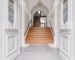 Repräsentatives Treppenhaus im sanierten Altbau mit Holztreppe und historischen Türen
